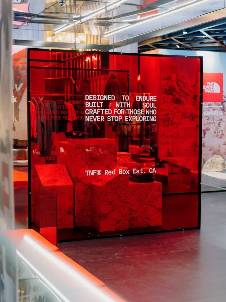 Red translucent acrylic cube installation with white type