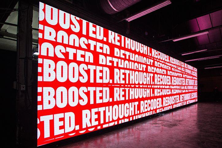 Wide LED wall displaying repeating white type on red