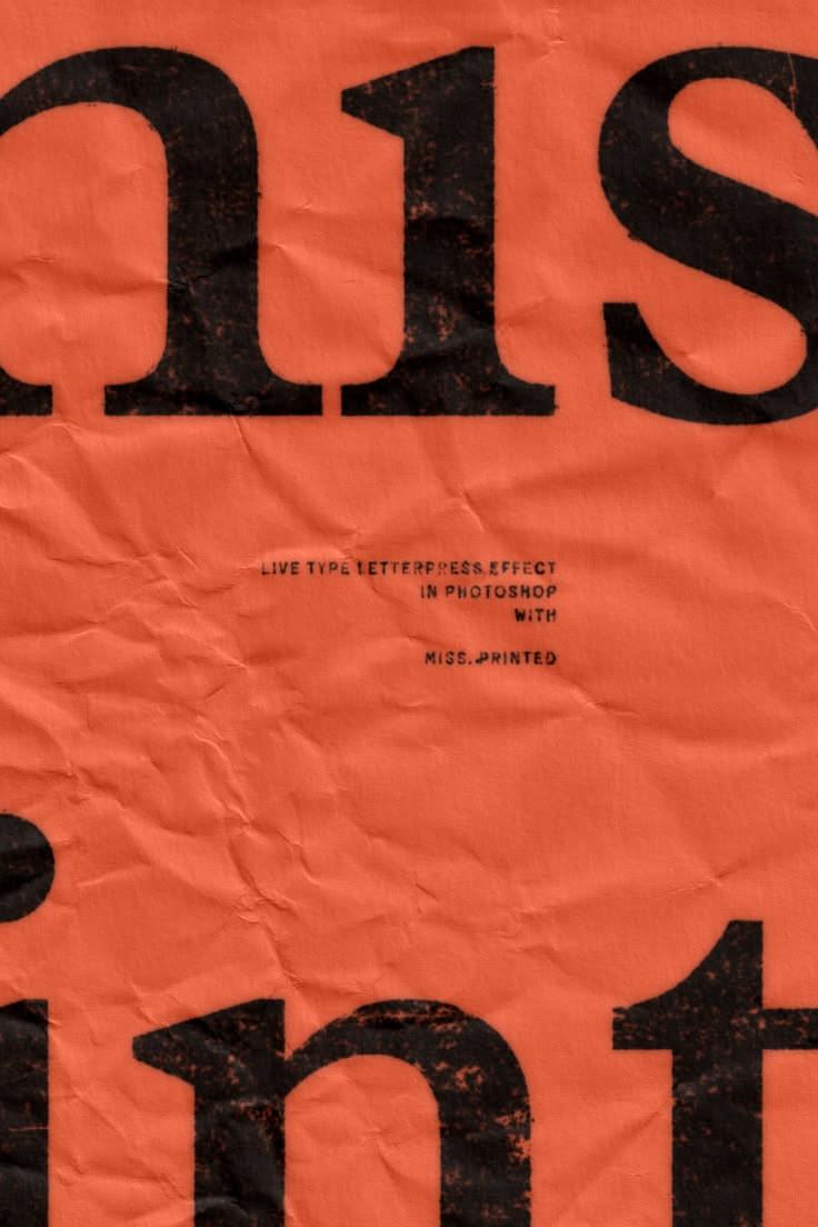 Heavy black letterforms printed on creased orange-red paper